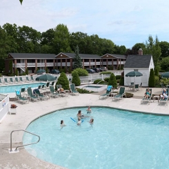 People swimming in outdoor pool in front of hotel near lounger chairs in Ogunquit, ME
