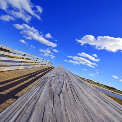 Footbridge over waterway near shoreline under blue sky in Ogunquit, ME