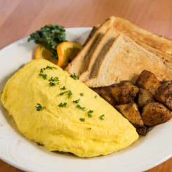 Omelette with potatoes, toast and orange garnish on white plate in Ogunquit, ME