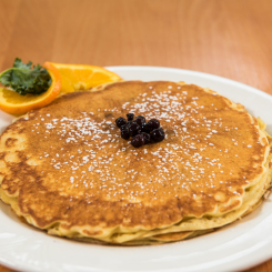 Pancake with Blueberry Topper and orange garnish on white plate in Ogunquit, ME