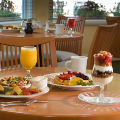 Table with breakfast items including mimosas, yogurt parfait, waffles, fruit and coffee in Ogunquit, ME
