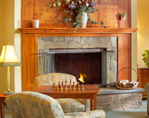 Two Chairs and A Table with A Chess Set At Ogunquit Hotel In Front of Fireplace