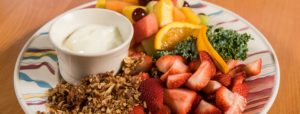 A fruit plate with granola, strawberries, oranges, melon and a garnish in Ogunquit, ME