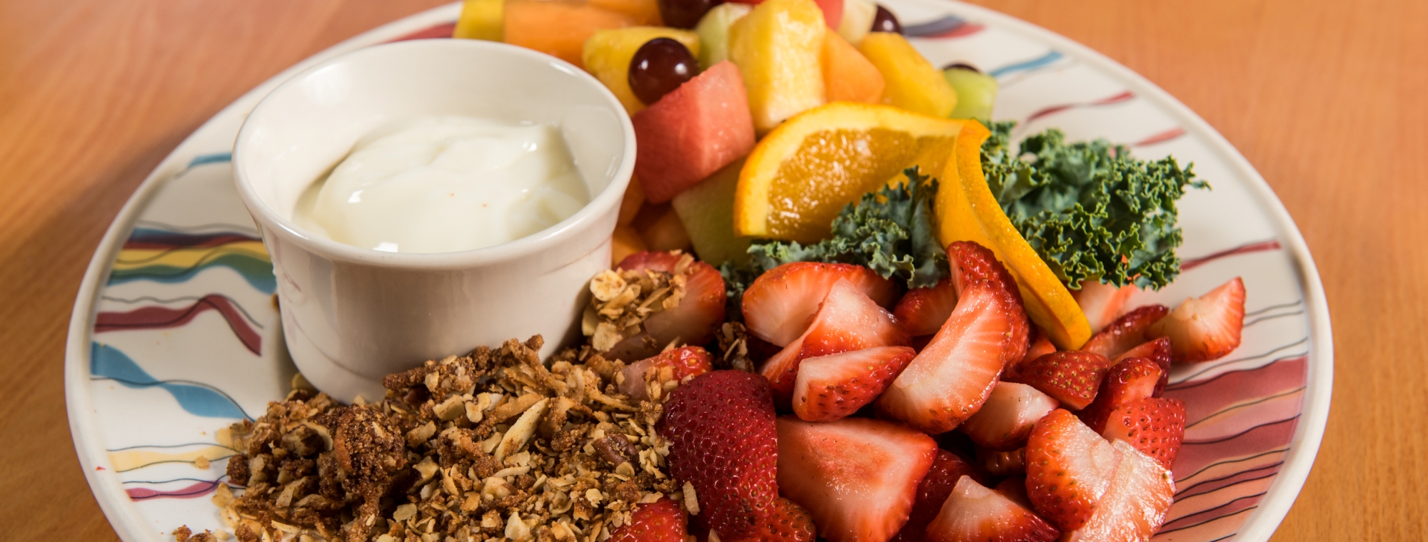 A fruit plate with granola, strawberries, oranges, melon and a garnish in Ogunquit, ME