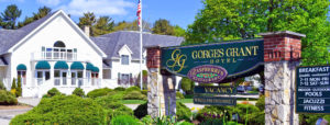 Entrance to Gorges Grant Hotel in the morning near American flag and trees near entry sign in Ogunquit, ME