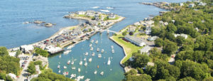 Aerial Shot of Ogunquit, Maine with Buildings, Homes and A Group of Boats on The Ocean