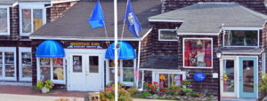 Ogunquit, ME storefronts near flag poles with blue flags