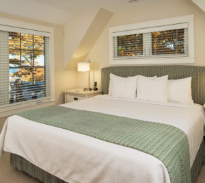 Queen-Size Bed with White Linens and Tan Blanket at Ogunquit Accommodations